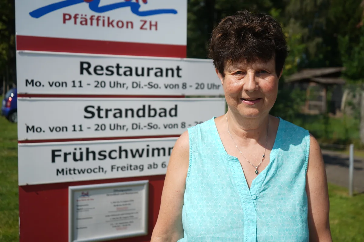 Frau steht vor dem Schild der Badi am See in Pfäffikon.